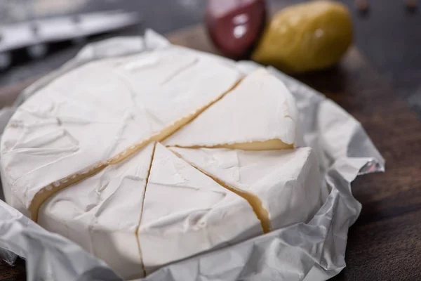 Close up view of cut brie cheese on wooden cutting board — Stock Photo