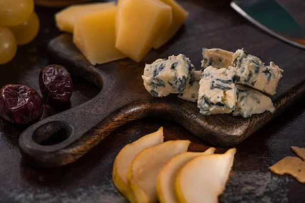 Close up view of cheese platter with olives, grapes and sliced pear — Stock Photo