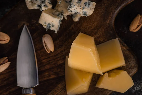 Top view of cheese platter with pistachios near knife — Stock Photo