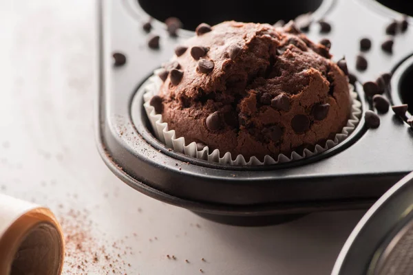 Vista de cerca del muffin de chocolate fresco en lata de muffin - foto de stock