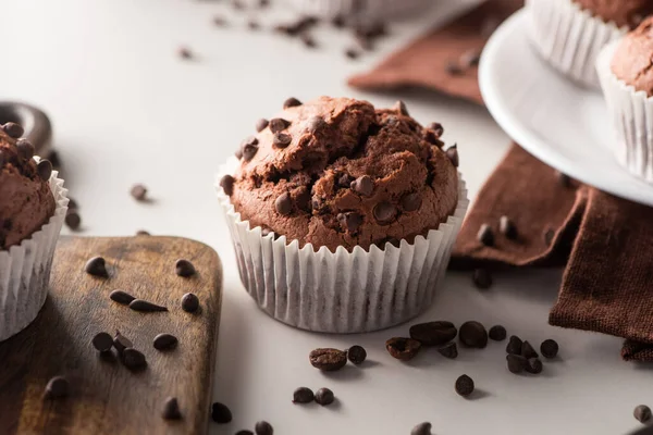 Vista de cerca del muffin de chocolate fresco en la superficie blanca - foto de stock