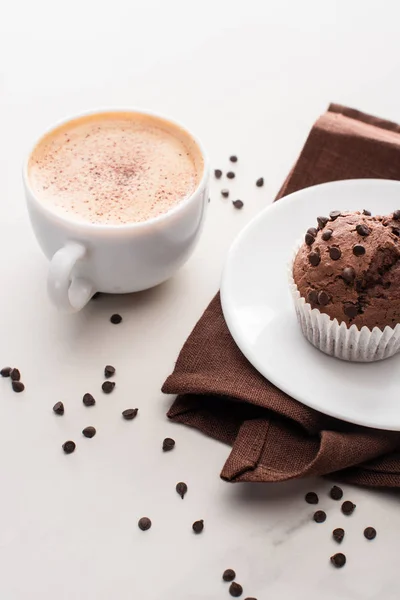 Fresh chocolate muffins on white plate near napkin and coffee — Stock Photo