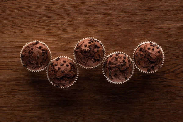 Vue de dessus des muffins au chocolat frais sur la surface en bois — Photo de stock