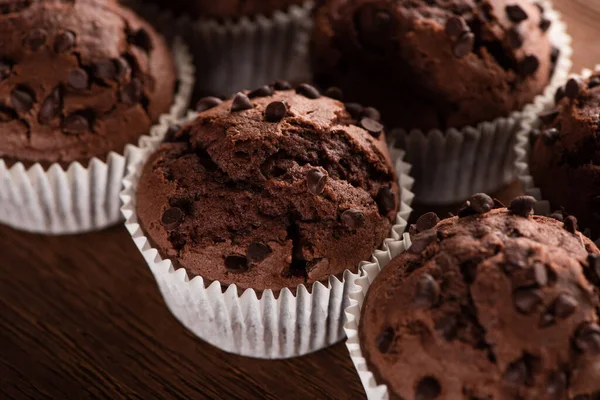 Vista da vicino dei muffin al cioccolato freschi sulla superficie di legno — Foto stock