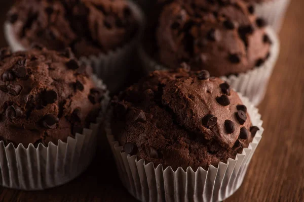 Vista da vicino dei muffin al cioccolato freschi sulla superficie di legno — Foto stock
