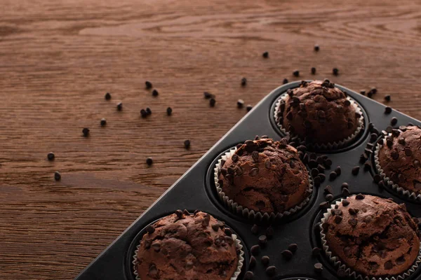 Крупным планом вид свежих шоколадных кексов в олове для кексов на деревянной поверхности — стоковое фото
