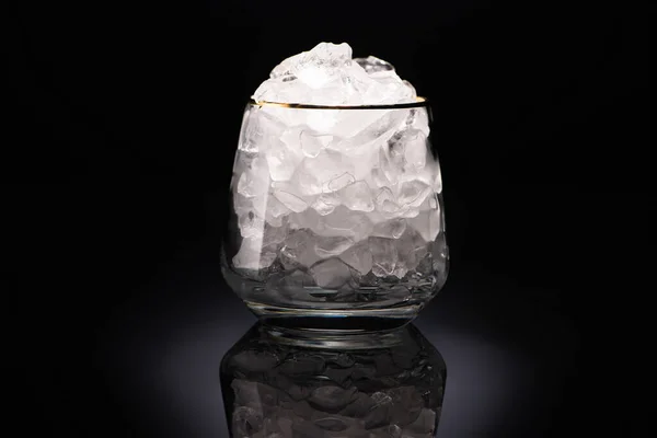 Transparent glass with ice on black background — Stock Photo