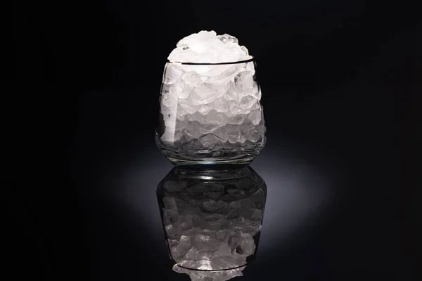 Transparent glass with ice on black background — Stock Photo