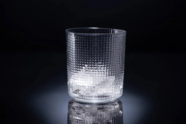 Faceted glass with ice on black background — Stock Photo