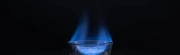 Transparent glass with burning liquid isolated on black, panoramic shot — Stock Photo