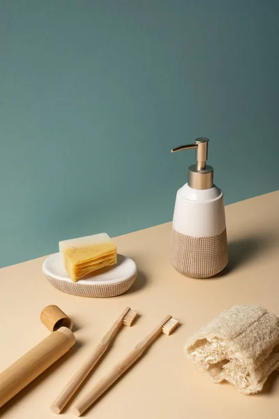 Toothbrushes, toothbrush case with dispenser, sponge and soap dish on beige and grey, zero waste concept — Stock Photo