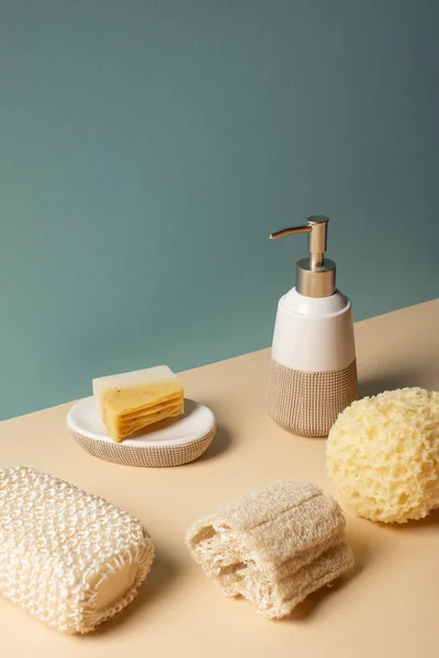 Spugne con dispenser di sapone liquido e portasapone su beige e grigio, concetto zero rifiuti — Foto stock