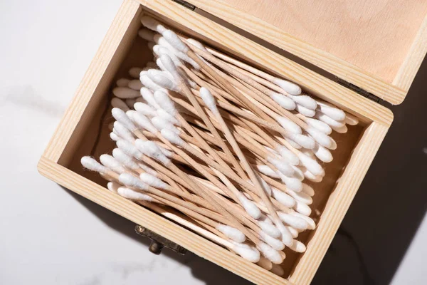 Vue du dessus de la boîte ouverte avec des bâtons d'oreille sur fond blanc, concept zéro déchet — Photo de stock