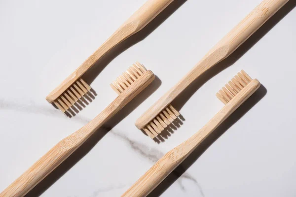 Vista dall'alto di spazzolini da denti in legno su sfondo bianco, concetto di zero rifiuti — Foto stock