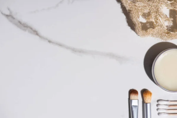 Top view of cosmetic brushes, sponge, jar of wax and ear sticks on white background, zero waste concept — Stock Photo