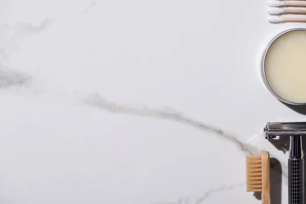 Vista superior da escova de dentes, navalha, jarra de cera e auriculares no fundo branco, conceito de desperdício zero — Fotografia de Stock