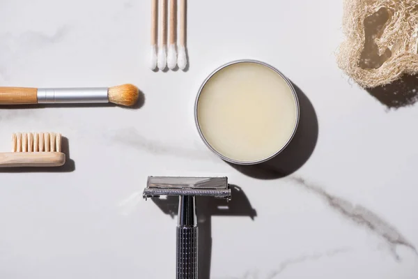 Vue de dessus de brosse cosmétique, brosse à dents, rasoir, pot de cire et bâtons d'oreille sur fond blanc, concept zéro déchet — Photo de stock