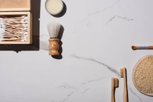 Vista dall'alto di spazzolini da barba e cosmetici, spazzolini da denti, barattolo di cera, scatola di bastoncini per le orecchie, spugna su sfondo bianco, concetto di zero rifiuti — Foto stock