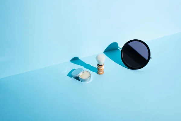 Miroir, pot de cire et brosse à raser sur fond bleu, concept zéro déchet — Photo de stock