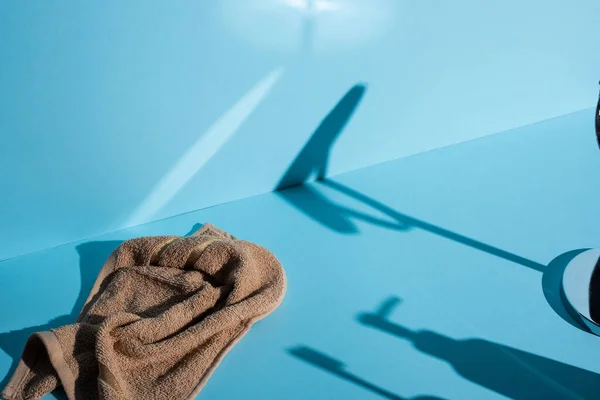 Toalla y sombras sobre fondo azul, concepto de cero residuos - foto de stock