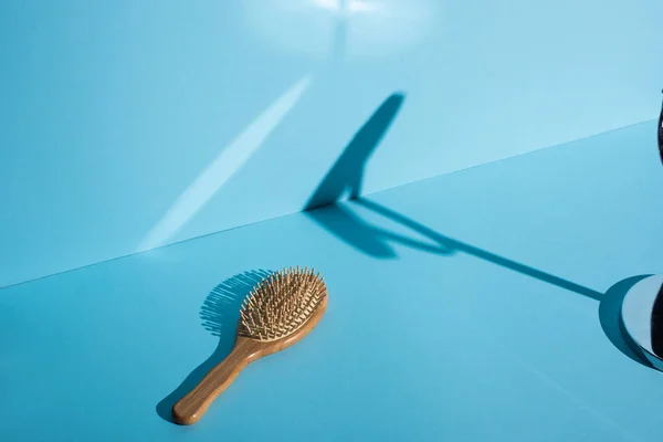 Cepillo y sombra de madera sobre fondo azul, concepto de cero residuos - foto de stock