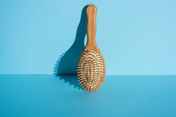 Escova de cabelo de madeira em fundo azul, zero conceito de resíduos — Fotografia de Stock