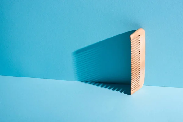 Peigne en bois avec ombre sur fond bleu, concept zéro déchet — Photo de stock