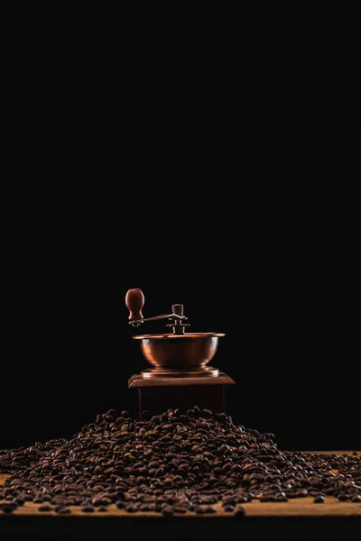 Moedor de café em grãos de café torrados frescos isolados em preto — Fotografia de Stock