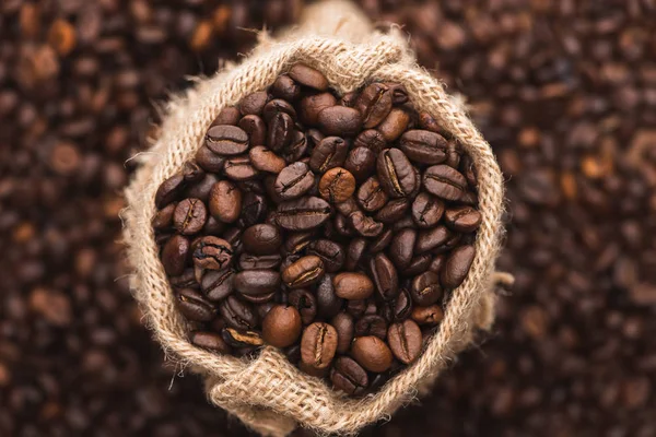 Selective focus of fresh roasted coffee beans in sack — Stock Photo