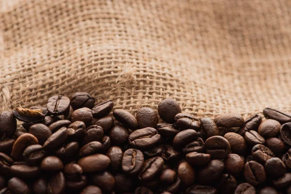 Vista da vicino di chicchi di caffè tostato fresco a sacco — Foto stock