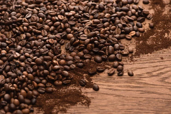 Chicchi di caffè tostato fresco e caffè macinato sul tavolo di legno — Foto stock