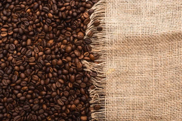 Vista dall'alto di chicchi di caffè tostato fresco e sacco — Stock Photo