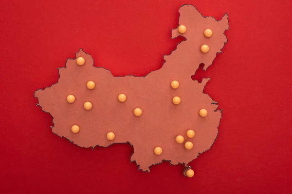 Vista superior del mapa de china con alfileres de empuje amarillos sobre fondo rojo - foto de stock