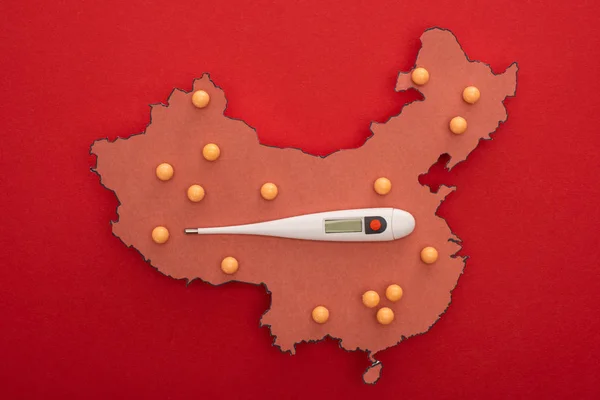 Ansicht des Thermometers auf der Karte von China mit Stecknadeln auf rotem Hintergrund — Stockfoto