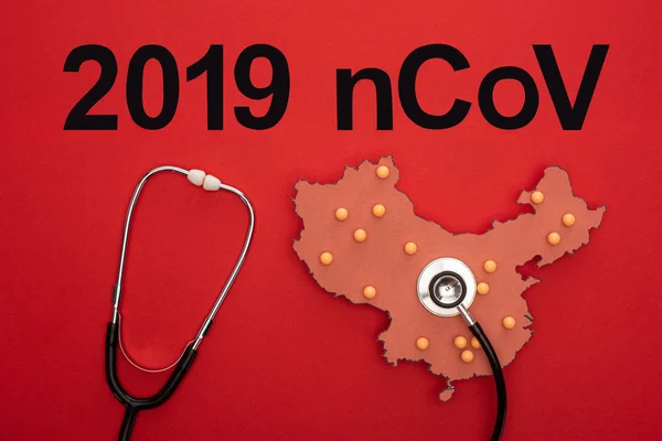 Vue du dessus du stéthoscope sur la mise en page de la carte de la Chine avec le lettrage 2019 ncov sur fond rouge — Photo de stock