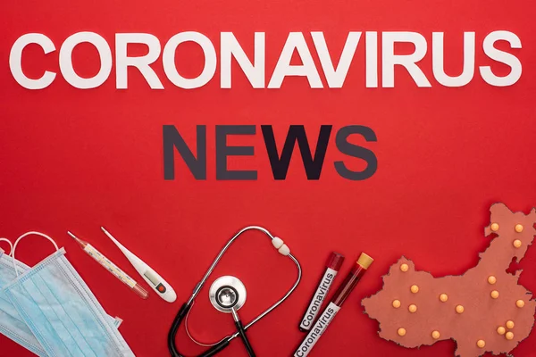 Vista superior de lettering notícias coronavírus com equipamentos médicos e layout de mapa china na superfície vermelha — Fotografia de Stock