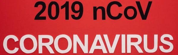 Top view of 2019 ncov and coronavirus lettering isolated on red, panoramic shot — Stock Photo