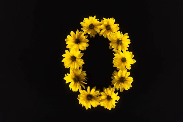Vue de dessus des marguerites jaunes disposées en lettre O isolées sur noir — Photo de stock