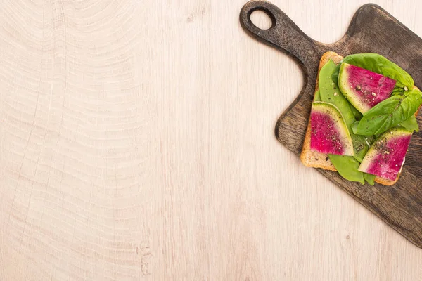Vista superior do sanduíche de rabanete vegetariano na placa de corte de madeira — Fotografia de Stock