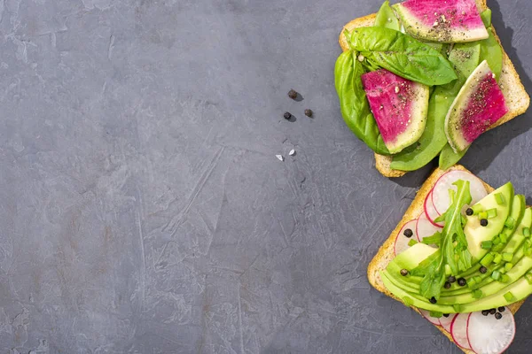 Vista dall'alto di brindisi vegetariano sano con ravanello, avocado e basilico — Foto stock