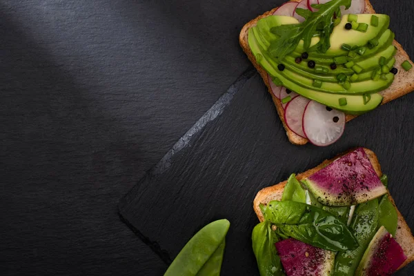 Top view of healthy organic sandwiches with vegetables on stone board — Stock Photo