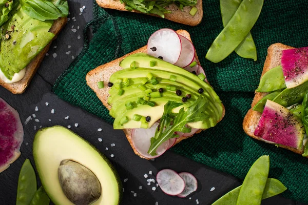 Vista superior de sándwiches vegetarianos con verduras frescas paño verde - foto de stock