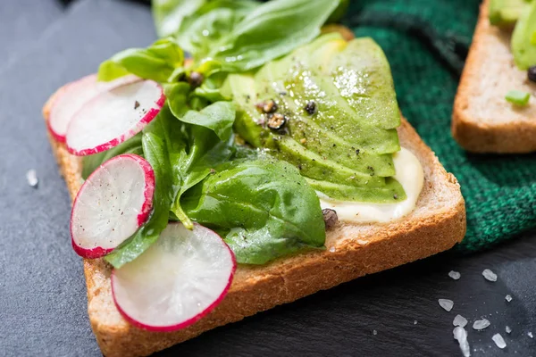 Close up of fresh toasts with radish, basil and avocado on cloth — Stock Photo