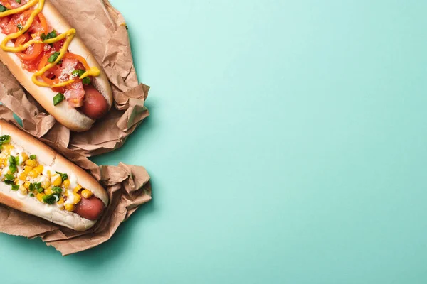 Vue de dessus de deux hot-dogs savoureux en papier sur bleu — Photo de stock