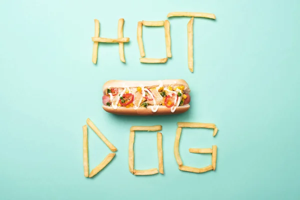 Top view of american hot dog on blue with word hot dog made from french fries — Stock Photo