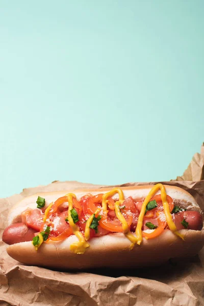 Top view of one delicious hot dog in paper isolated on blue — Stock Photo