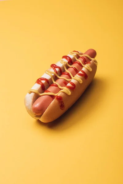 Delicioso hot dog americano con salchicha, mostaza y ketchup en amarillo — Stock Photo