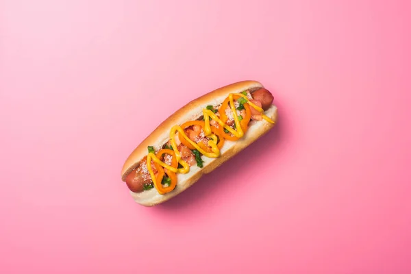 Vista superior de delicioso perrito caliente con salchicha en rosa - foto de stock