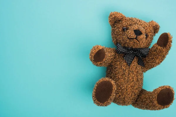 Draufsicht auf Teddybär mit Schleife auf blauem Hintergrund — Stockfoto