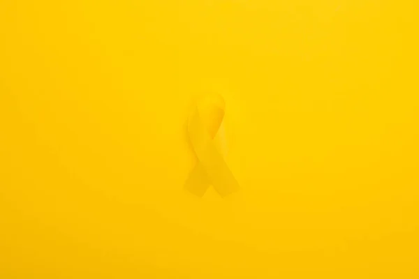 Vue du dessus du ruban jaune sur fond lumineux coloré, concept de journée internationale contre le cancer chez l'enfant — Photo de stock